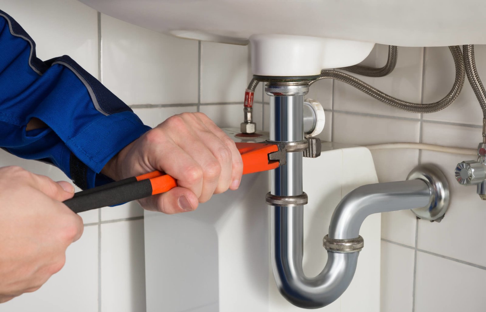 Plumber working on pipe and drain connection