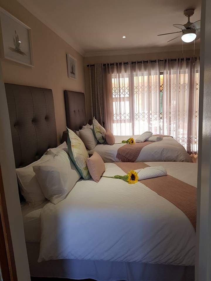 Comfortable guest bedroom with twin beds and sunflower accents at Therato Guest House