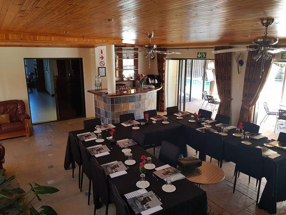 Conference and dining room setup with tables, chairs, and counter bar at Therato Guest House