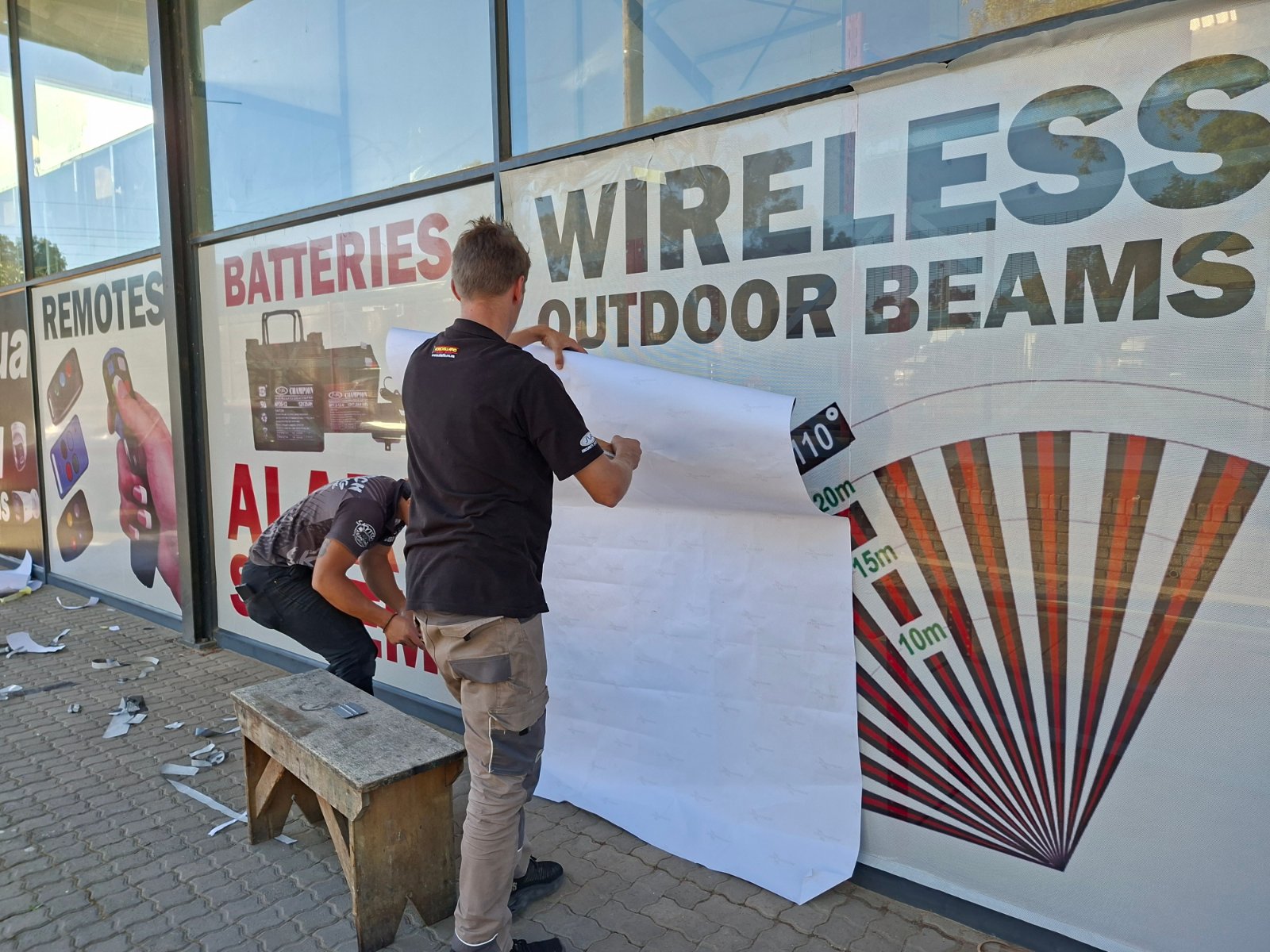 Skytech signage installation team applying vinyl window graphics