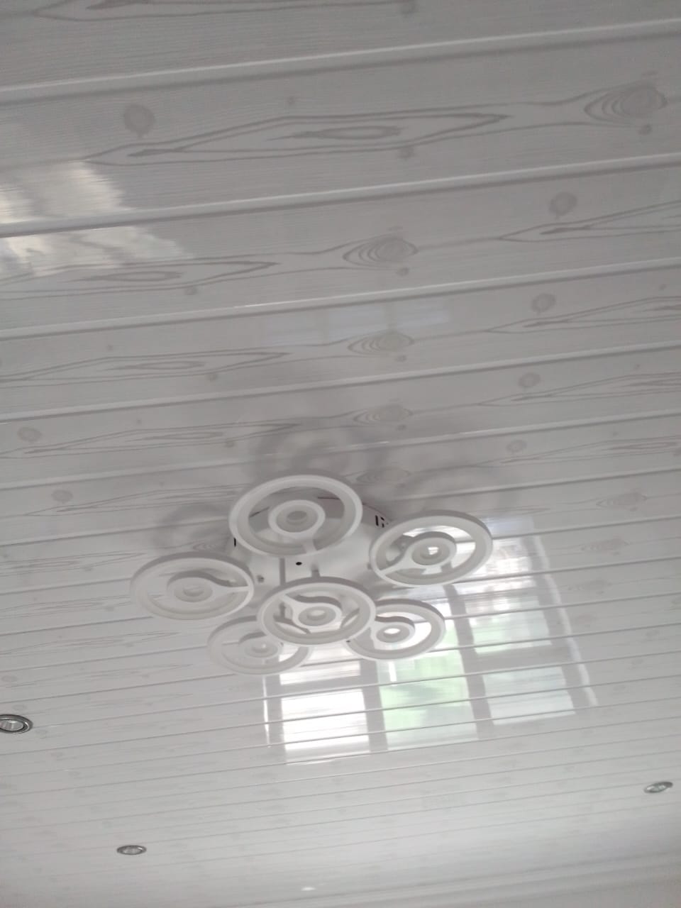 White panelled ceiling with a feature circular light fitting