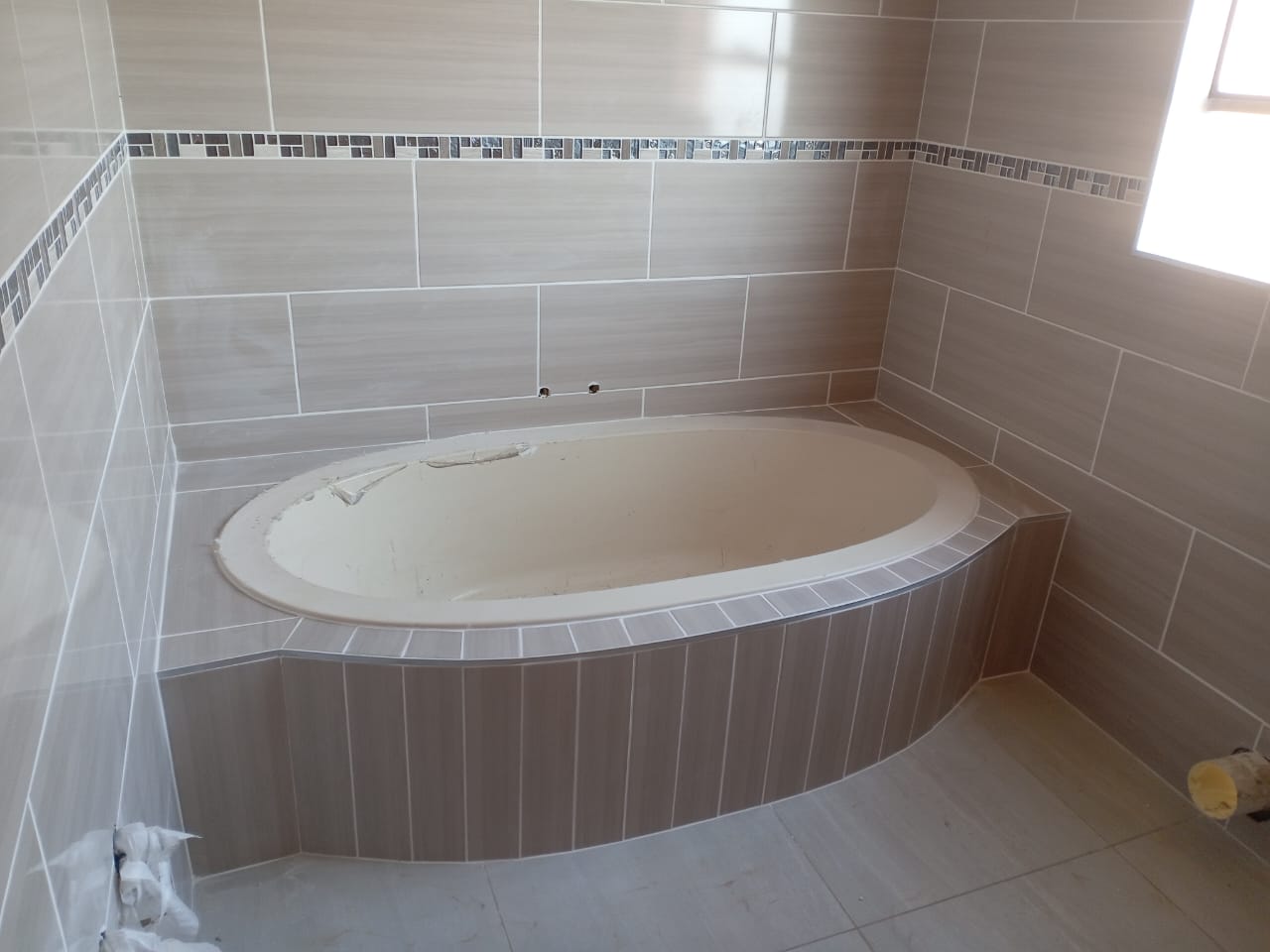 Oval bathtub installed in a tiled bathroom