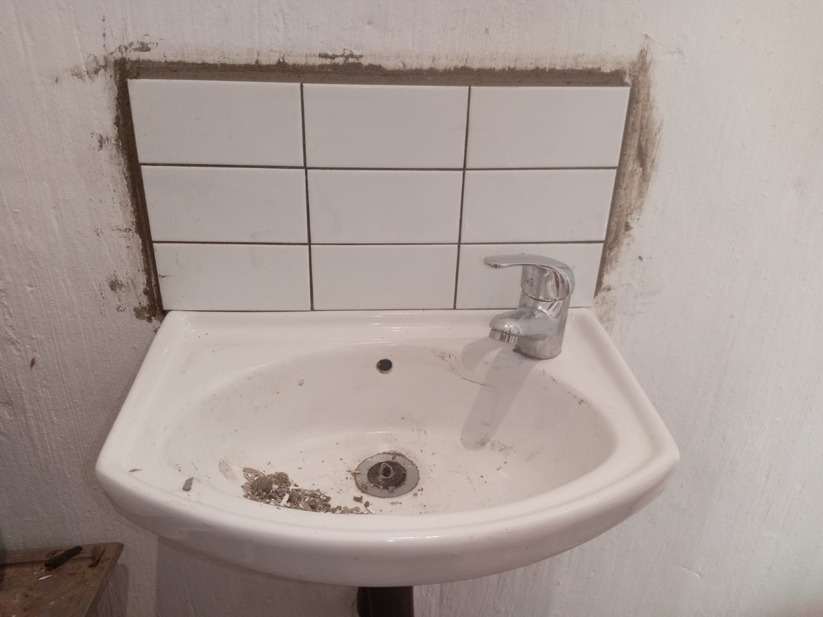 White sink with a tiled backsplash