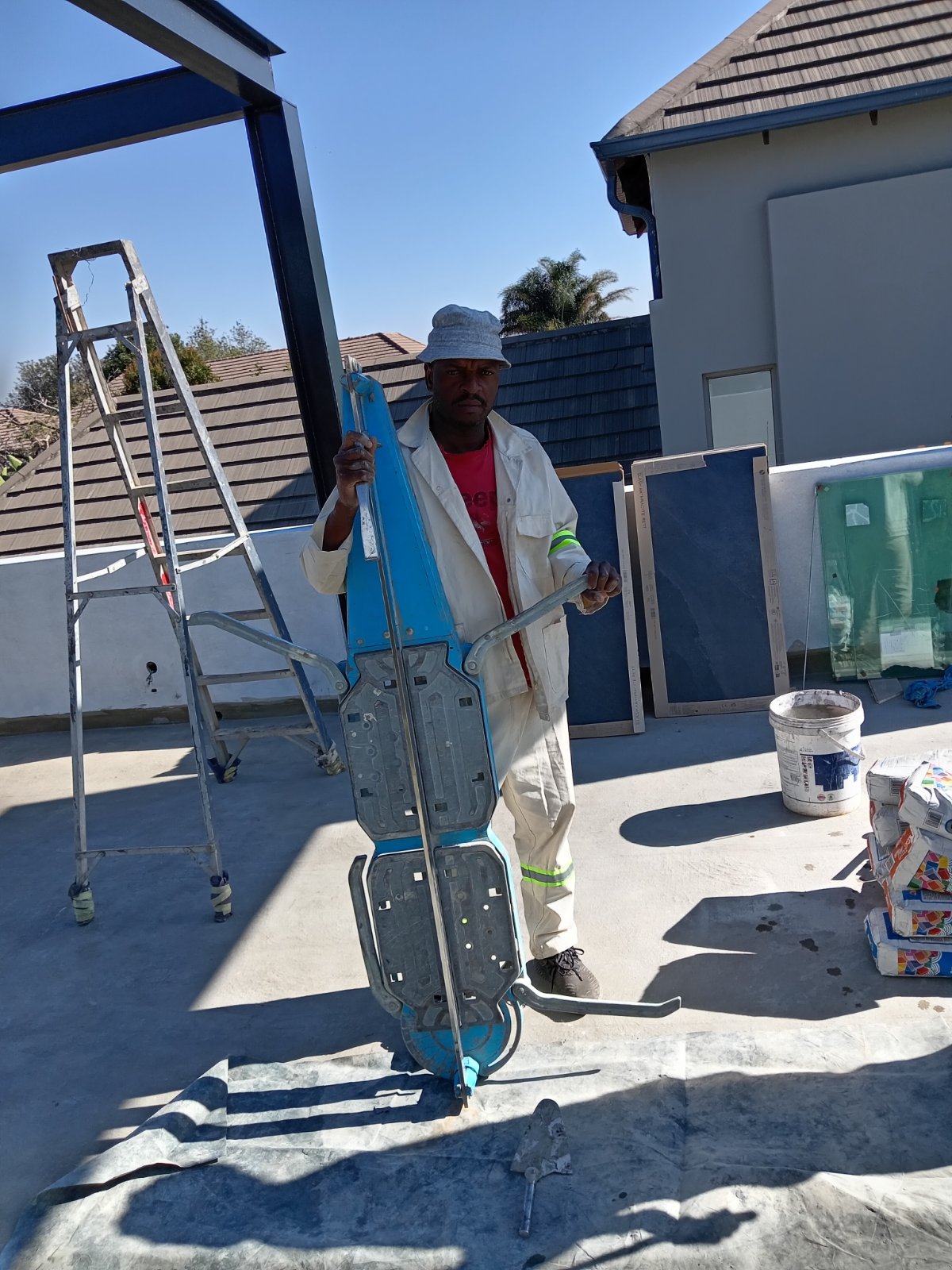 Stanley holding a large blue tile cutter