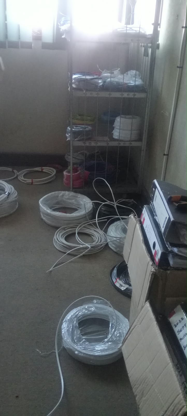 Rolls of white and black cable stacked on the floor of the store
