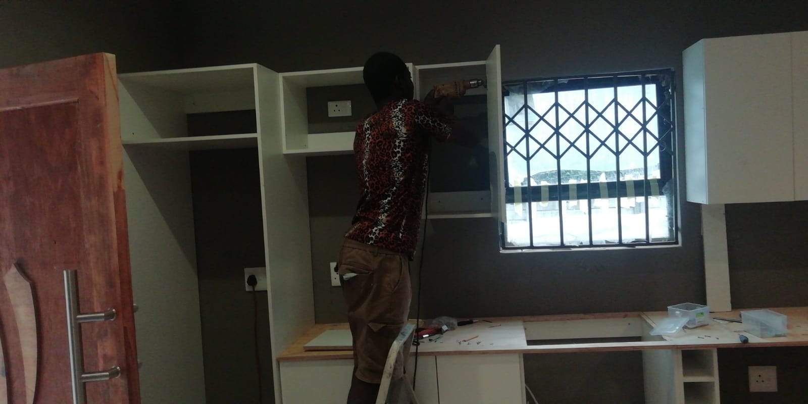 Carpenter fitting white kitchen cabinets